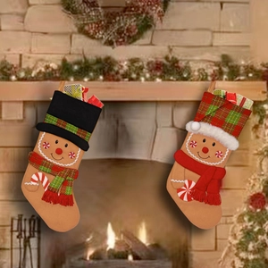 Detail of two gingerbread man Christmas stockings with gift box decor on a festive mantle