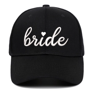 Black cotton baseball cap with white embroidered bride text and heart detail on white background
