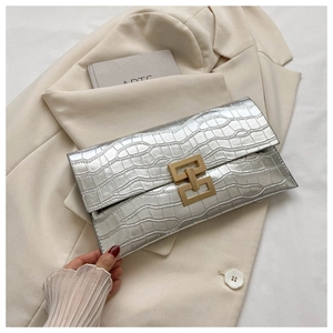 Detail of silver stone-textured envelope clutch bag with gold metallic lock closure