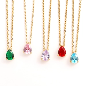 Detailed view of five gold teardrop birthstone necklaces in green pink purple red and blue