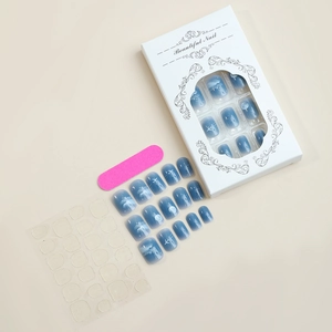 Detail of press-on nail kit with blue gradient moon patterns and professional packaging