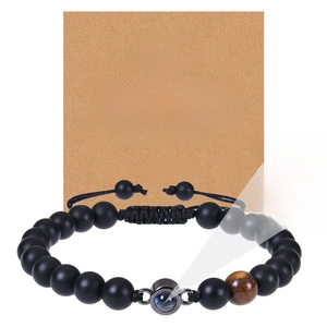 Detailed view of frosted black bead bracelet with projection stone on message card
