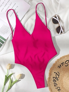Magenta one-piece swimsuit laid flat with sun hat, sunglasses and tulips for beach vibes