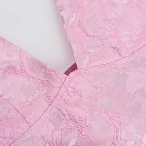 Macro shot of pink jacquard fabric texture and fine stitching on the evening dress