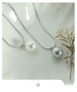 Detail of elegant white and grey pearl pendants on fine silver metal snake chains