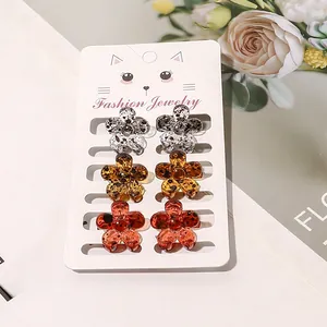 Detail of mini tortoiseshell flower hair claws on a fashion jewelry display card