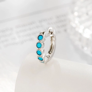 French vintage silver earring with five turquoise stones on a white podium