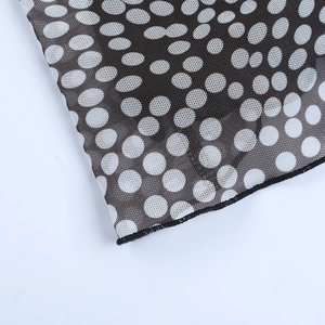 Detail of black mesh fabric with white polka dots and fine stitching on the dress