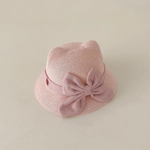 Detail of pink woven baby sun hat featuring cute cat ears and a large bow decoration