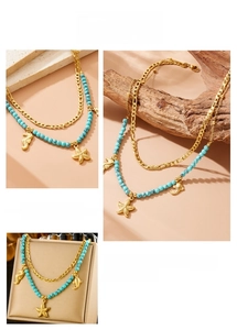 Detail of vintage gold-plated seahorse charms and turquoise beads on a layered necklace
