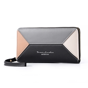 Detail of color-block patchwork wallet with wristlet strap and smooth metal zipper