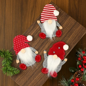 Trois porte-couverts de gnomes de Noël avec chapeaux rayés sur table festive