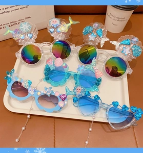 Close-up of heart-shaped Elsa and Ariel princess sunglasses with glitter and pearls