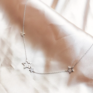 Elegant S925 sterling silver necklace with star pendants on smooth silk background