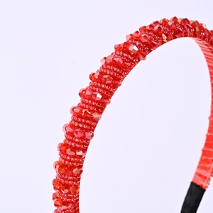 Vue détaillée du serre-tête en perles de cristal rouge montrant le travail des facettes
