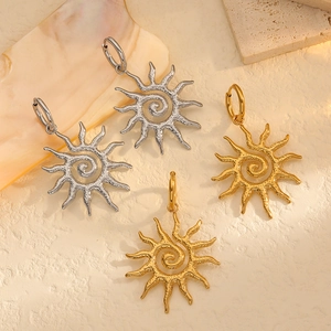 Retro sunflower earrings in gold and silver steel with spiral texture and wavy sun rays