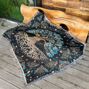 Bohemian tree of life woven blanket with colorful tassels on an artistic wooden bench