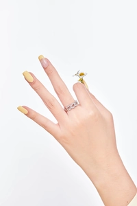 Detailed close-up of a silver chain-link ring with sparkling zircon stones on a model's hand