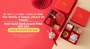 Detailed gift set featuring red ceramic mug, gold spoon, warmer pad, and festive towel