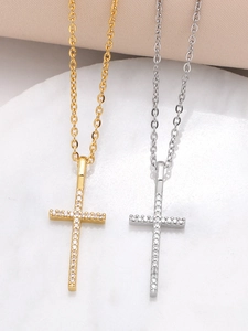 Close-up of gold and silver cross necklaces with sparkling pavé cubic zirconia