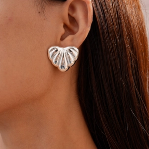 Close-up of minimalist silver shell earrings with a metallic finish on female model