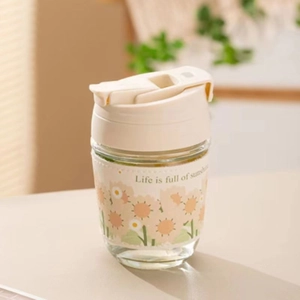 Detail of sunflower pattern glass cup with beige sleeve and Life is full of sunshine text