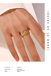 Macro view of gold flower ring showing intricate petal textures and hollow structure