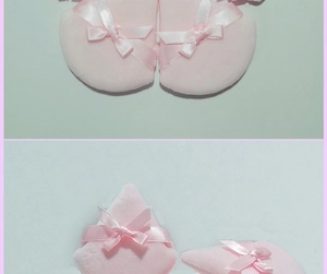 Detail of pink triangular makeup puff with soft velvet texture and white bow decoration