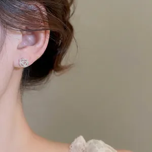 Pink opal cat eye stud earring with golden D-shaped metal border shown on a model