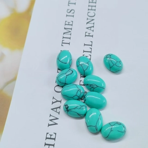 Macro shot of 11 oval turquoise cabochons with natural black matrix veins for jewelry