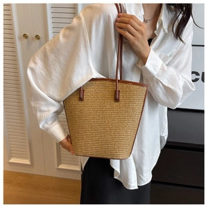 Detail showing woven straw texture and premium brown leather straps on the summer tote