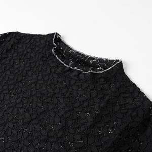 Dettaglio del collo in pizzo nero floreale con eleganti bordi a balze rifiniti