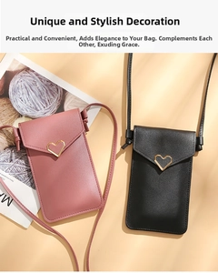 Pink and black crossbody phone bags with gold heart buckles on a warm yellow surface