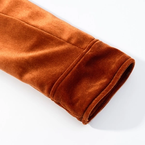 Detalle del puño doblado de esta chaqueta de terciopelo marrón naranja con costura fina