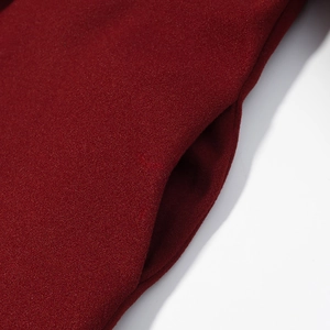 Detailed close-up of side pocket and wine red wool texture on long sleeve jacket