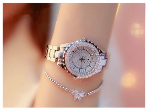 Close-up of a silver rhinestone-encrusted watch with matching butterfly charm bracelet
