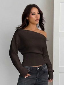 Détail du pull en maille à épaules dénudées montrant la texture et la coupe cintrée