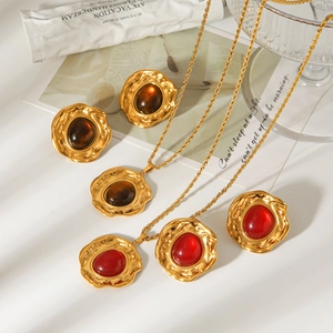 Detaillierte Nahaufnahme von Vintage-Bernstein und rotem Edelsteinschmuck in Goldoptik