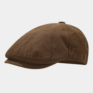 Detailed view of dark brown newsboy cap with vintage textured linen fabric and button top