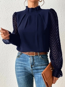 Detail of navy chiffon blouse featuring high pleated neck and sheer geometric textured sleeves
