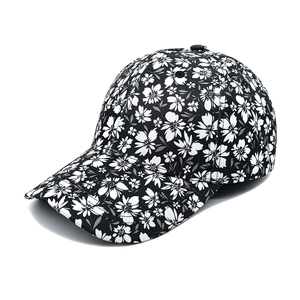 Close-up of baseball cap featuring black and white floral pattern with detailed stitching