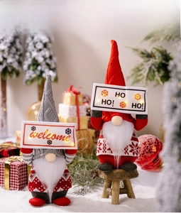 Detail of Christmas gnomes with LED welcome signs and festive knit holiday decorations