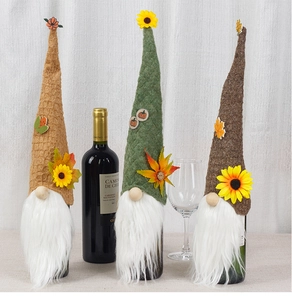 Detailed trio of felt wine bottle covers with sunflower, maple leaf and pumpkin motifs