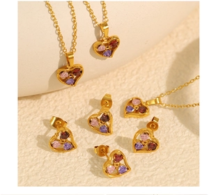 Close-up of heart jewelry set with pink purple and red crystals in 18k gold plating