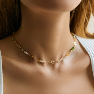 Close-up of model wearing a bohemian beaded necklace with heart charm and colorful beads
