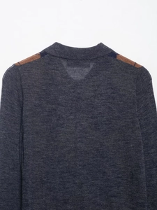 Close-up of knit polo shirt collar with brown and navy blue diamond pattern details