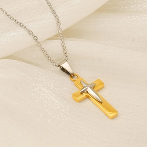 Détail du pendentif croix bicolore or et argent sur une fine chaîne métallique