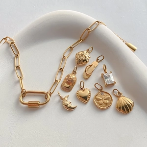 Detail van gouden roestvrijstalen bedelset met hart-, maan- en schelphangers voor dames