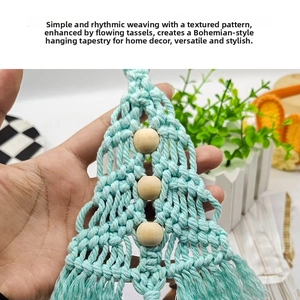Detail of mint green woven Christmas tree wall hanging with wooden beads and tassels