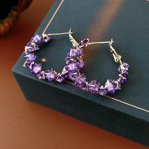 Detailed close-up of amethyst hoop earrings set on a premium jewelry gift box